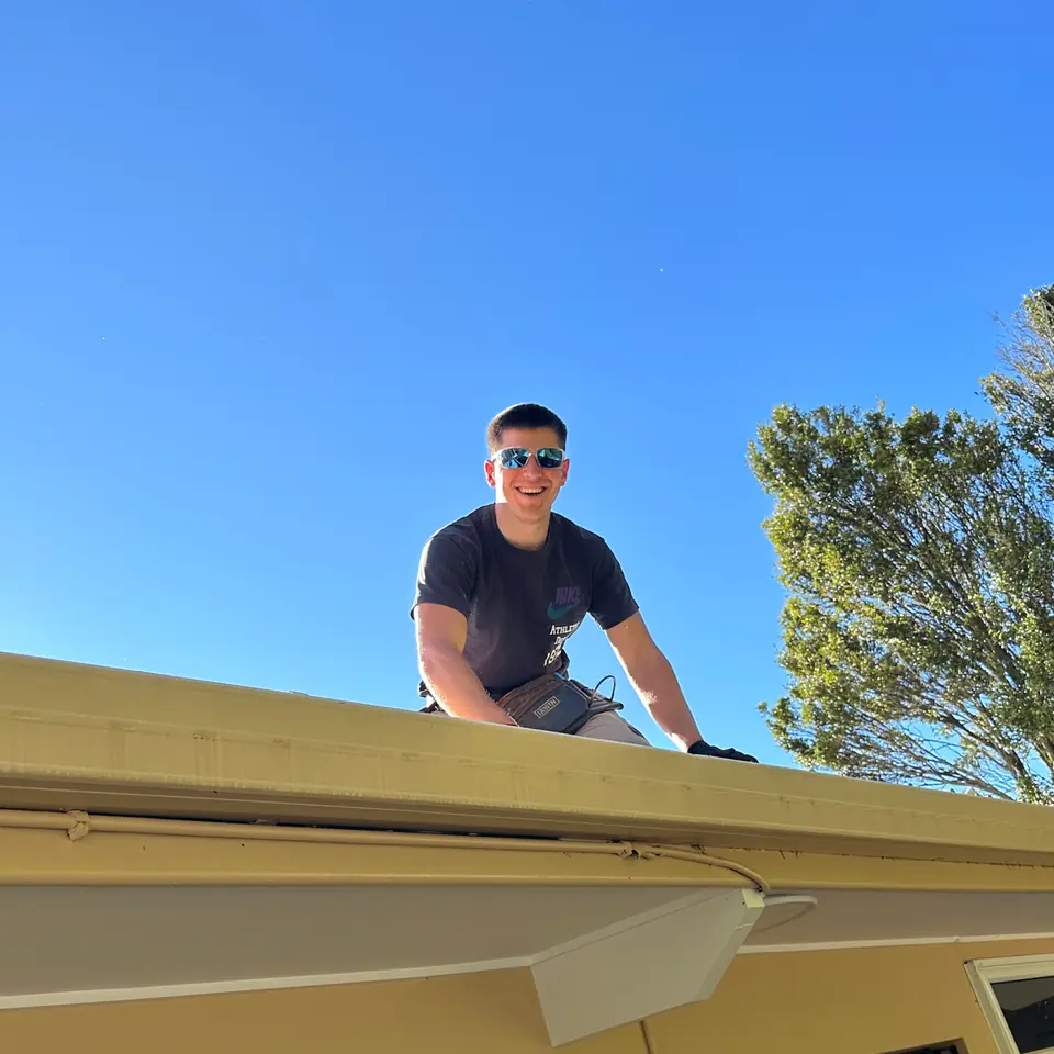 Roofer working at the gutter edge of a cream-coloured home