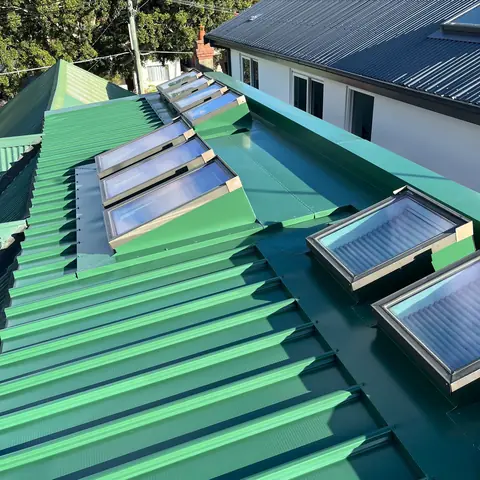 Finished green metal roof with multiple skylights