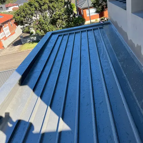 Dark blue metal roof panels in sunlight