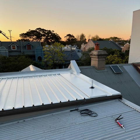 White metal roof against a warm sunset