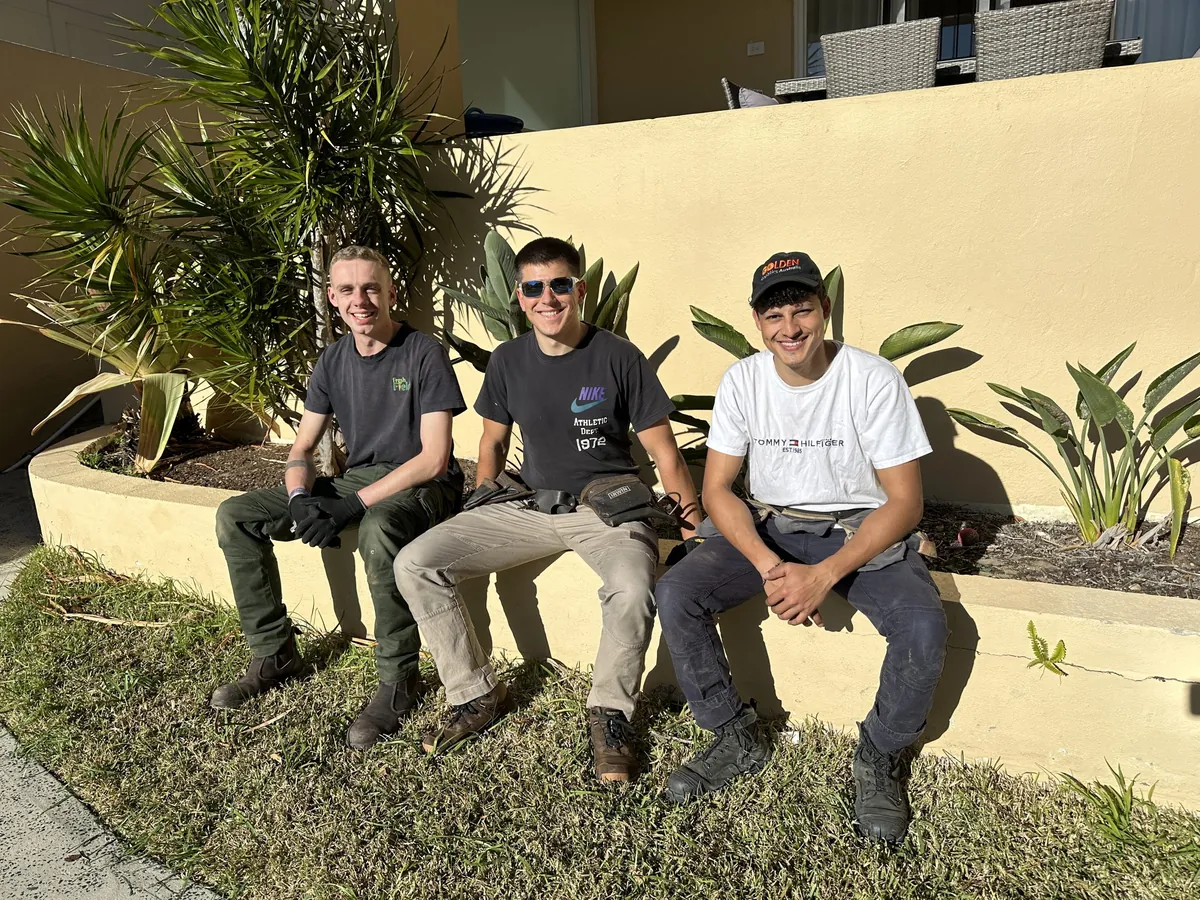 Naz seated with two members of his roofing crew